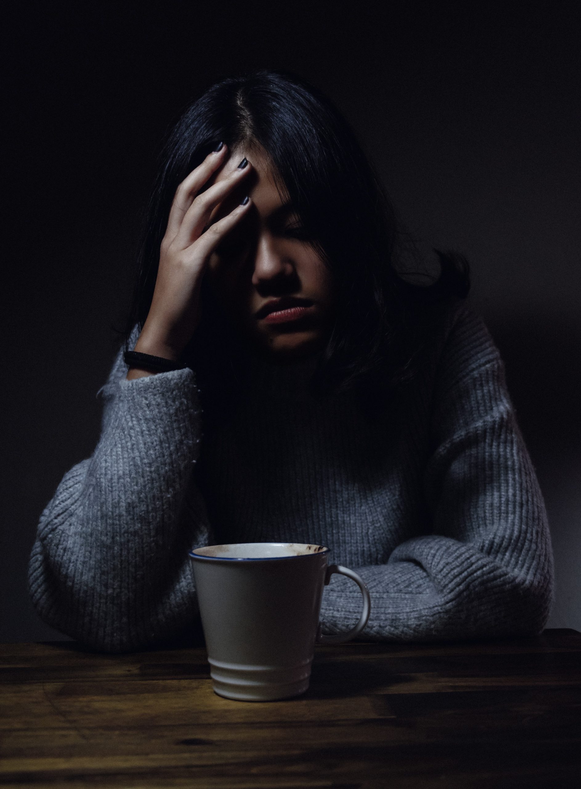 Woman sitting with head on hand looking sad